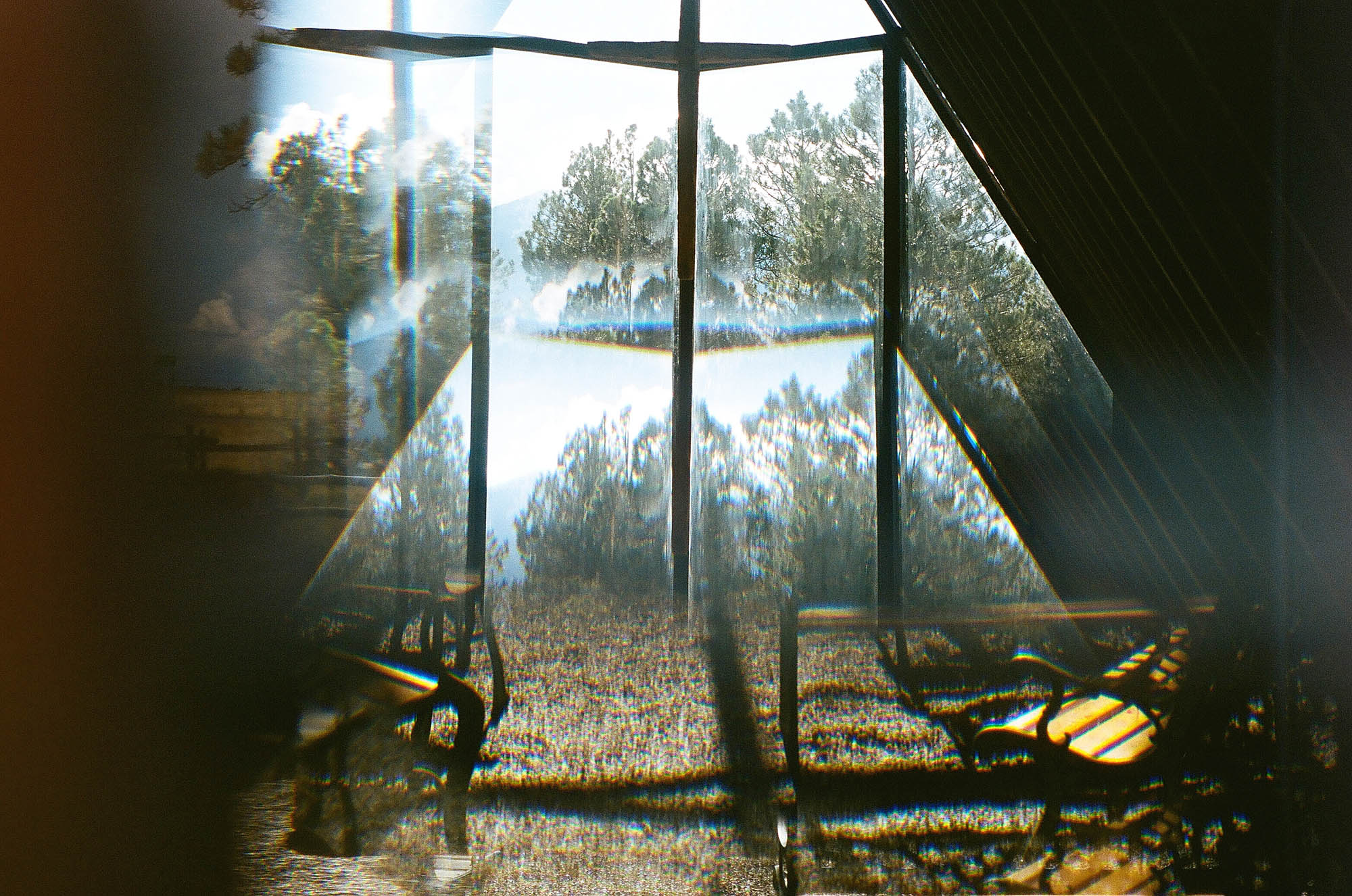 The interior of a small A-frame church refracted through a window