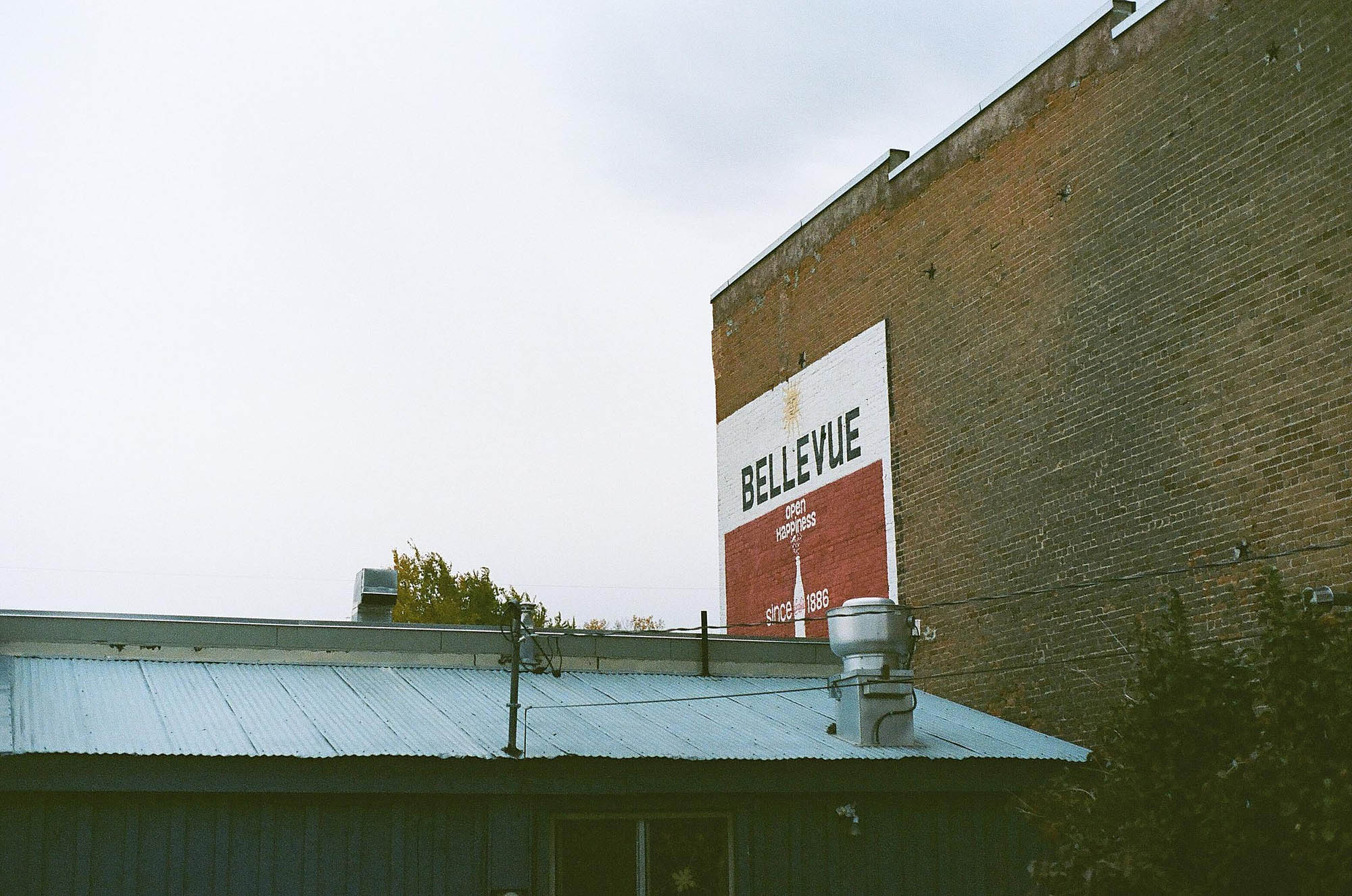 An advertisement for Coca Cola painted on the side of a brick building