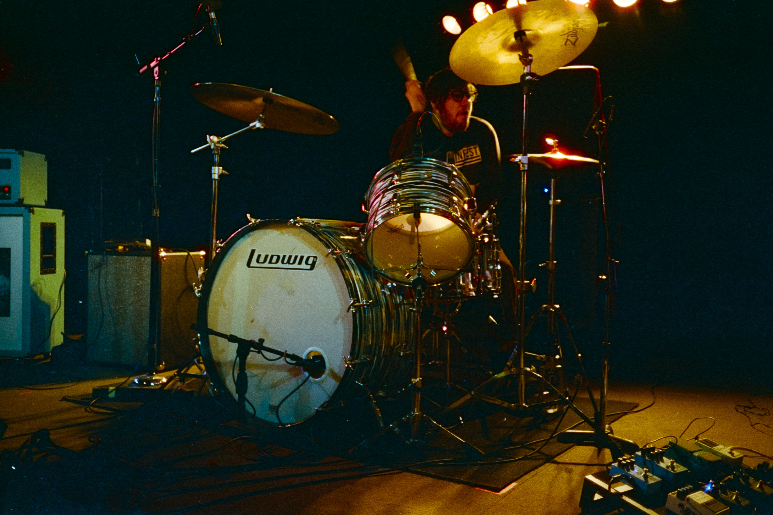 A drummer behind a drum kit onstage
