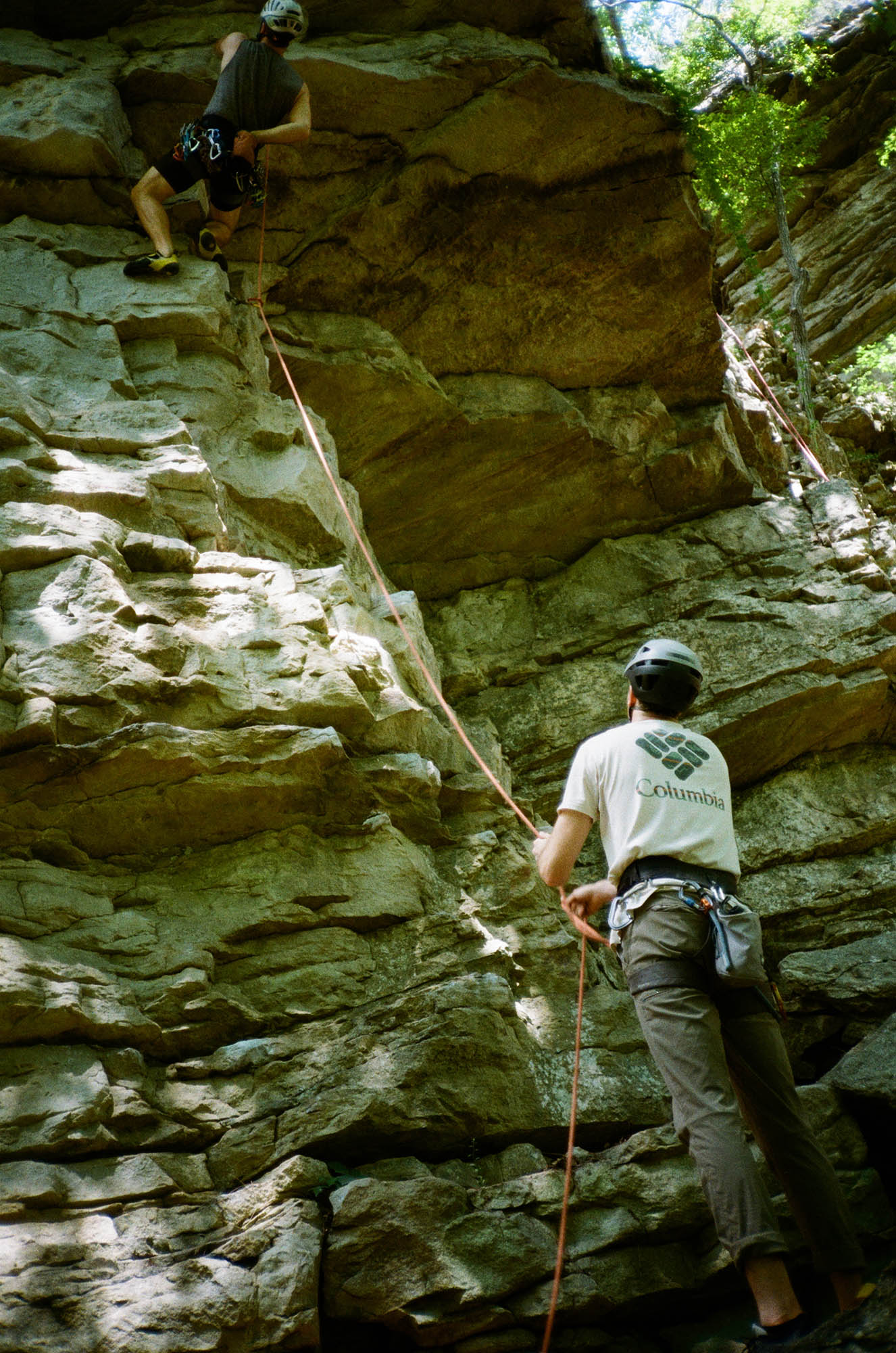 Two people climbing a rock wall