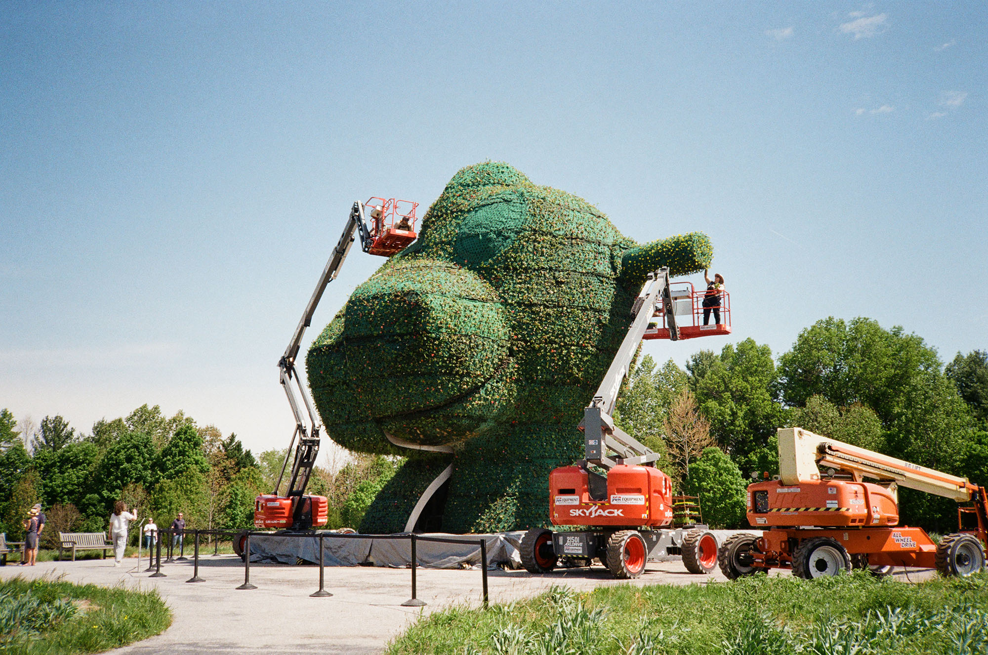 Workers planting floweres on Split Rocker by Jeff Koons