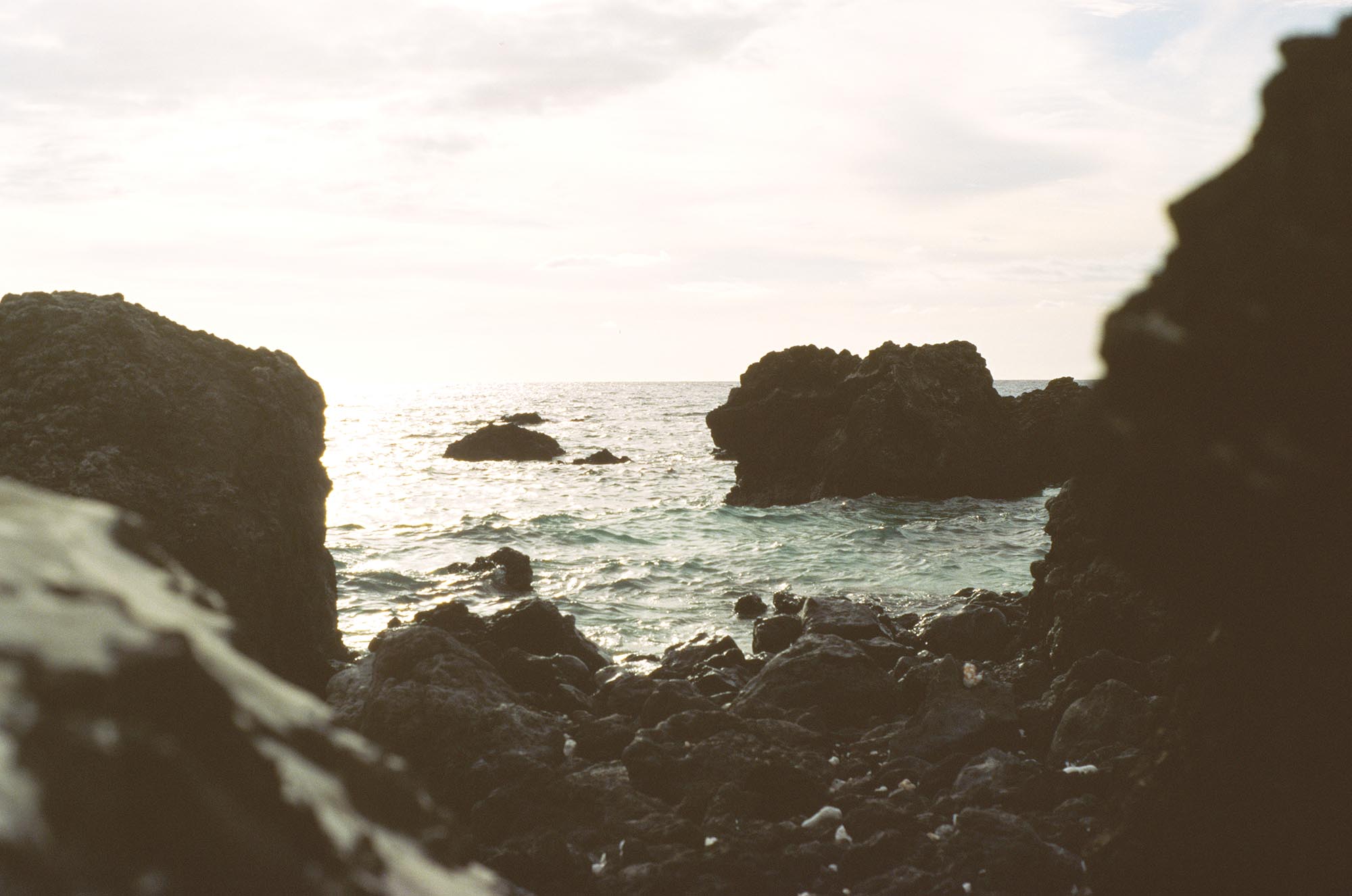 An inlet in the ocean glimpsed through rocks