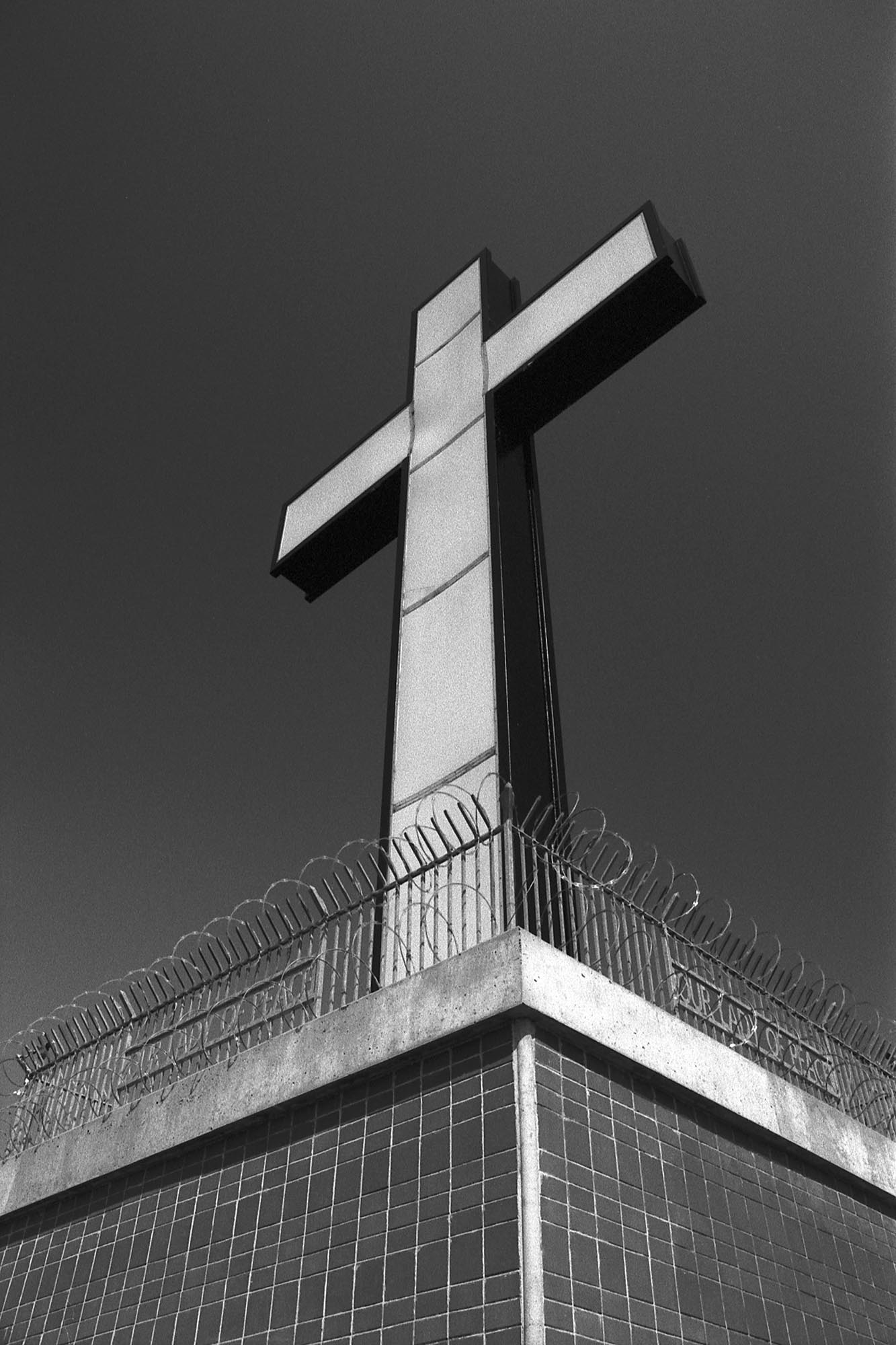 An enormous neon cross on a brick foundation