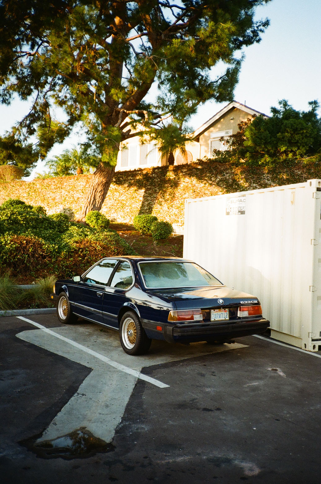 A black BMW 8 Series in a gas station parking lot