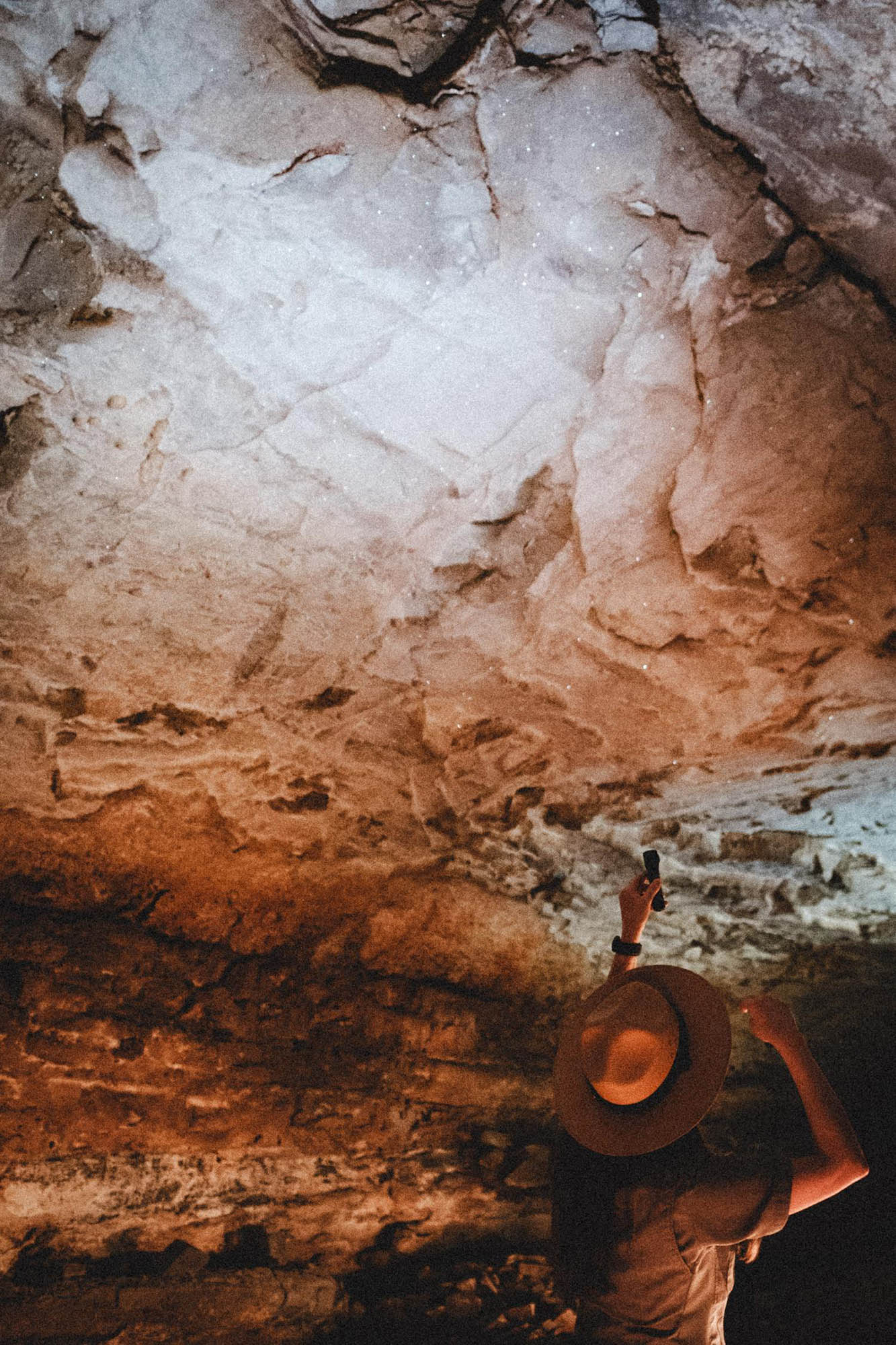 A tour guide pointing at a sparkling cave wall