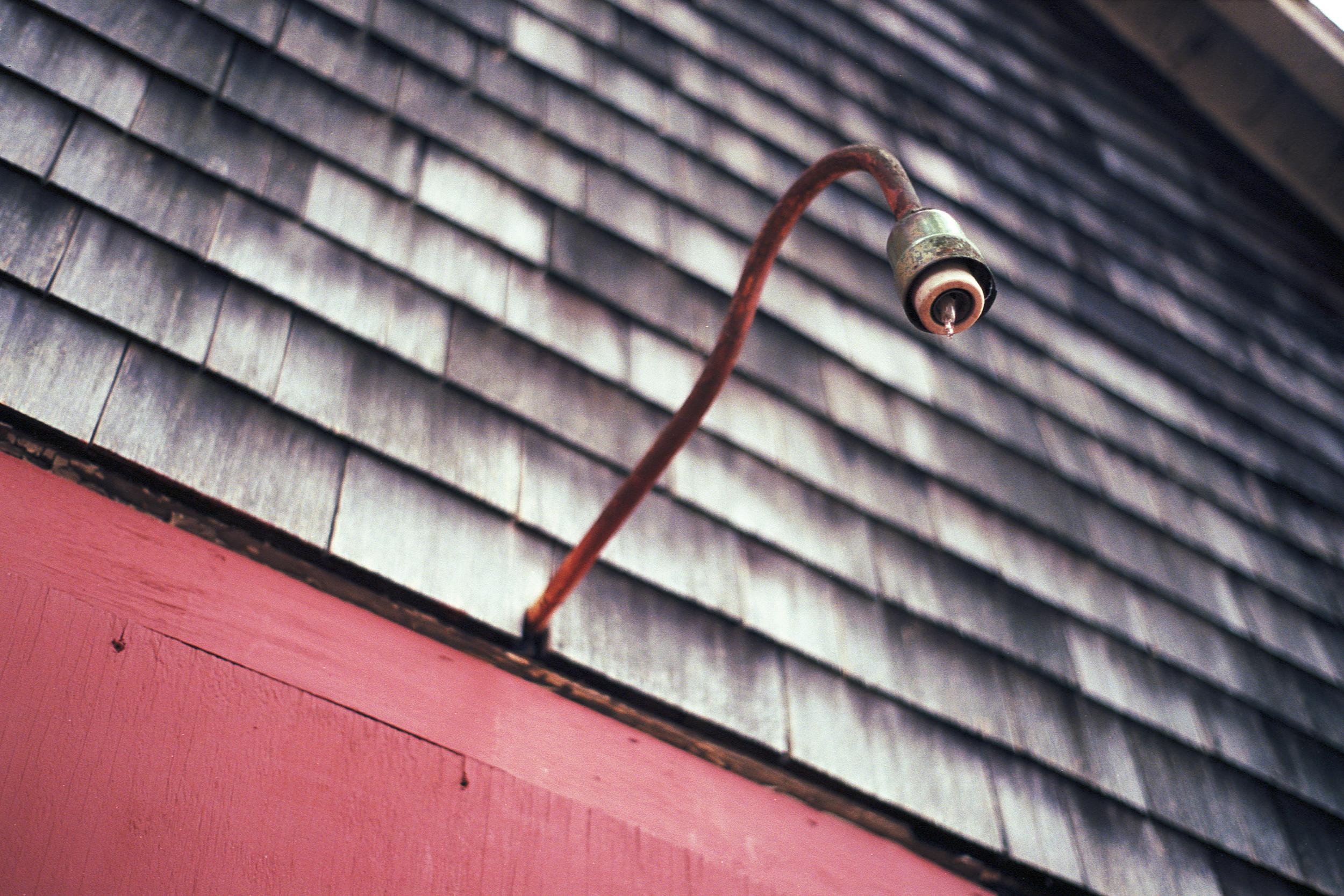 A rusted outdoor sconce with no lightbulb