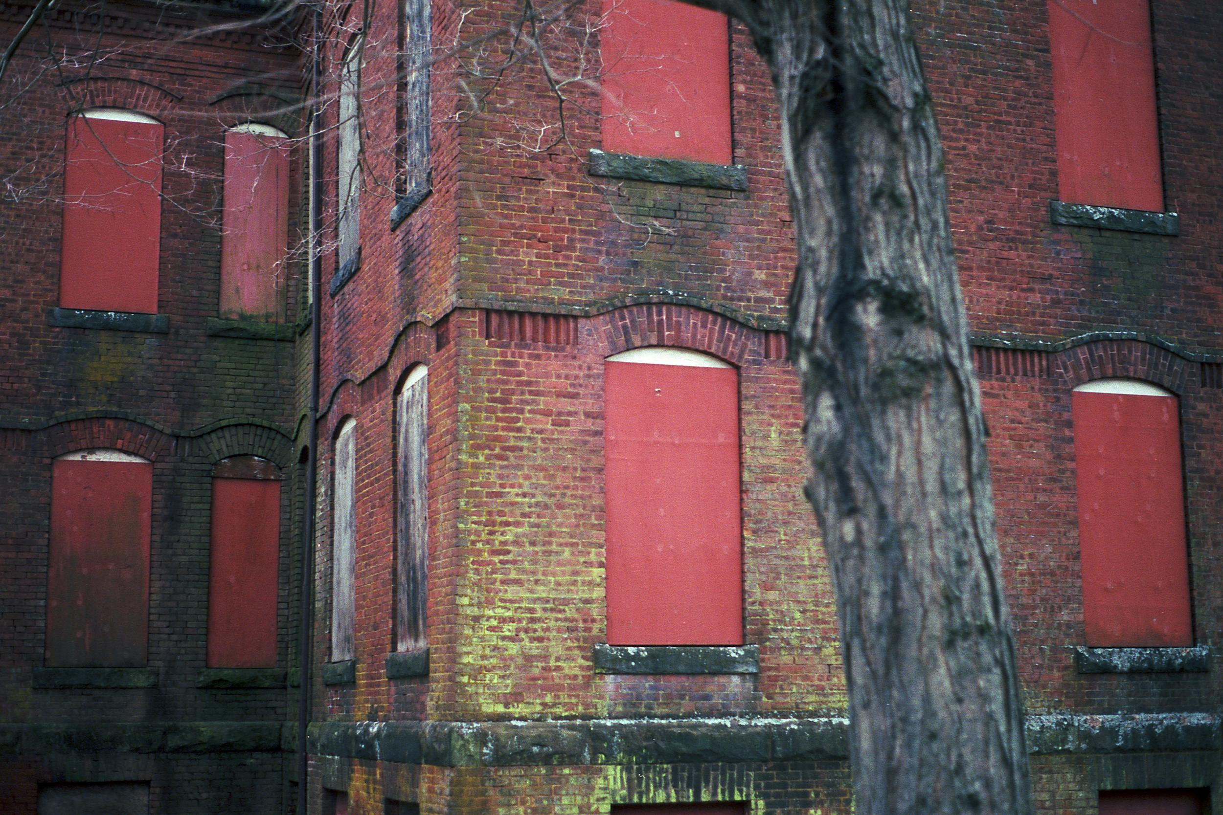 An abandoned hospital building with boarded up windows