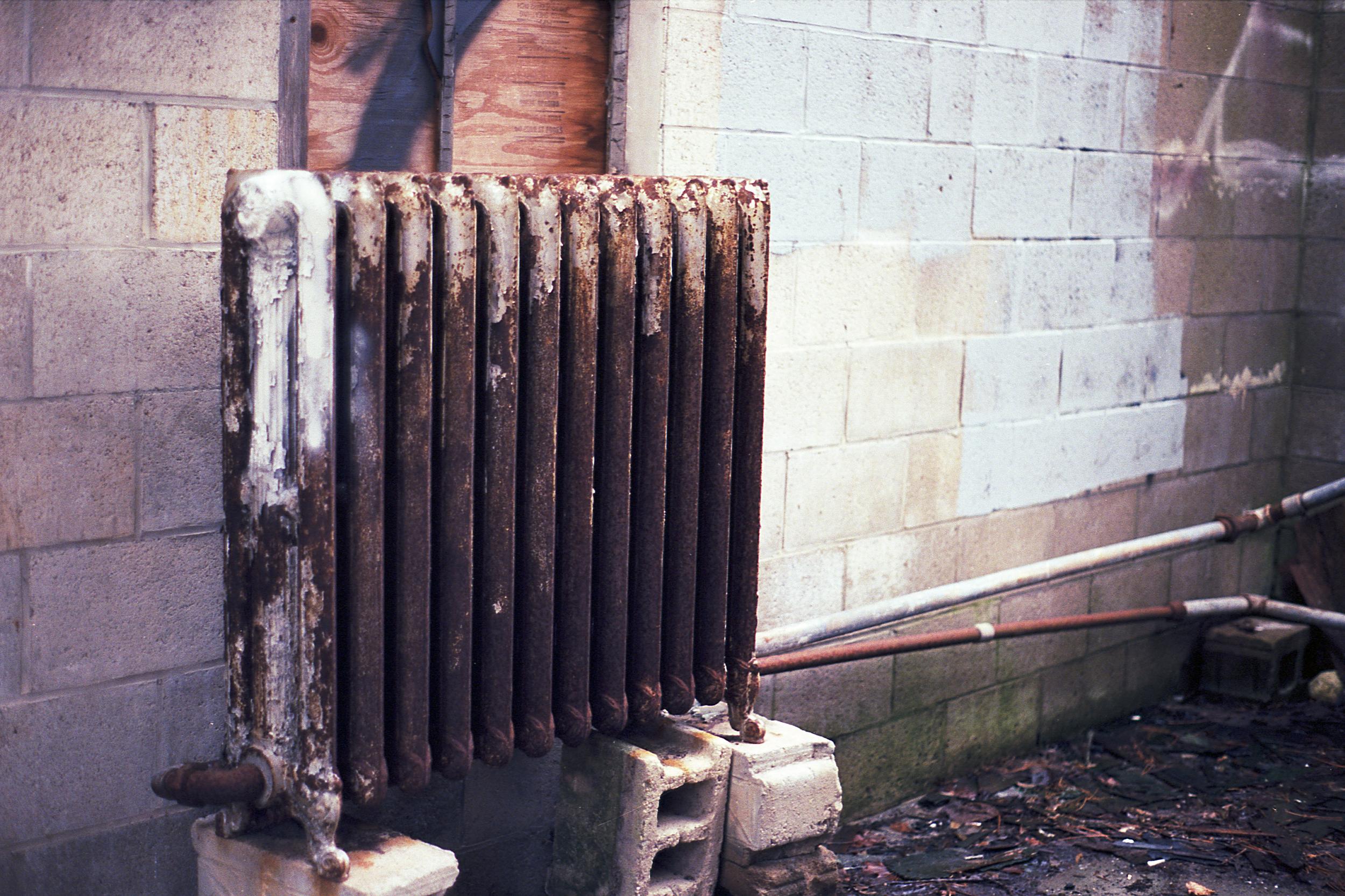 A rusty radiator sitting on cinderblocks