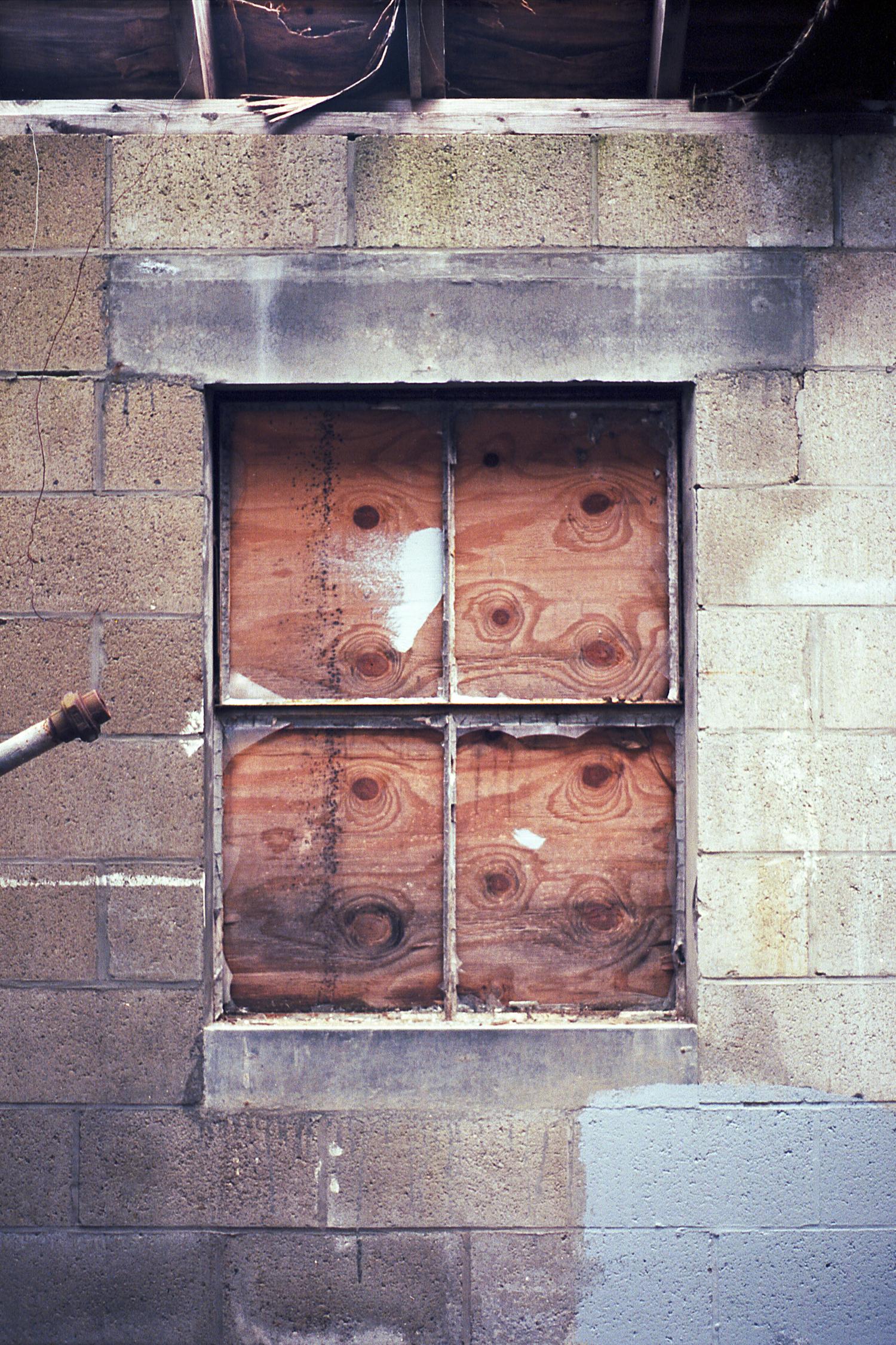 A boarded up smashed window