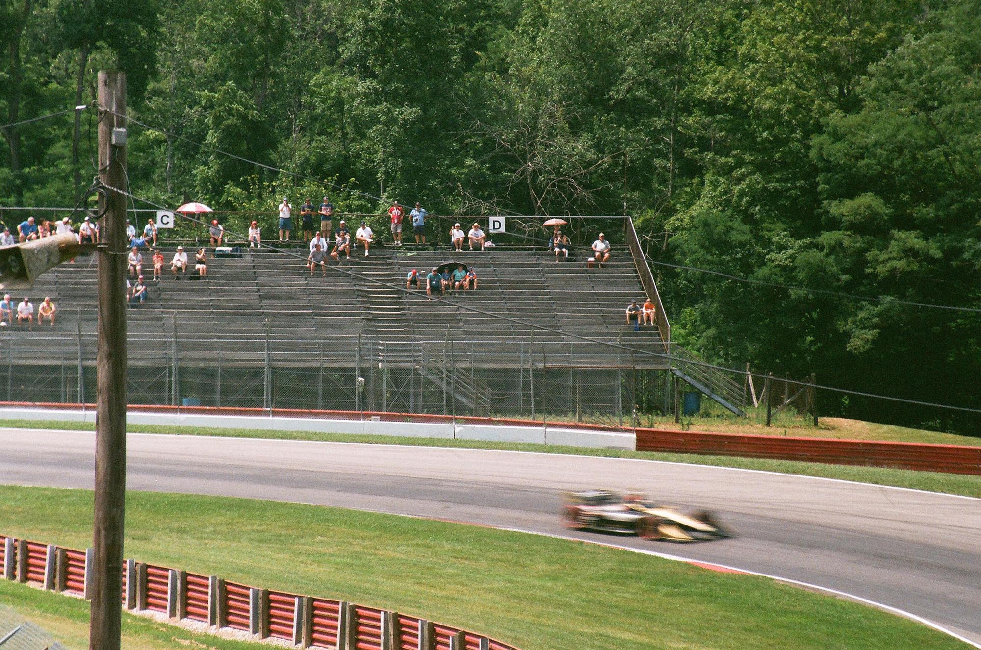 An IndyCar on track in front of bleachers