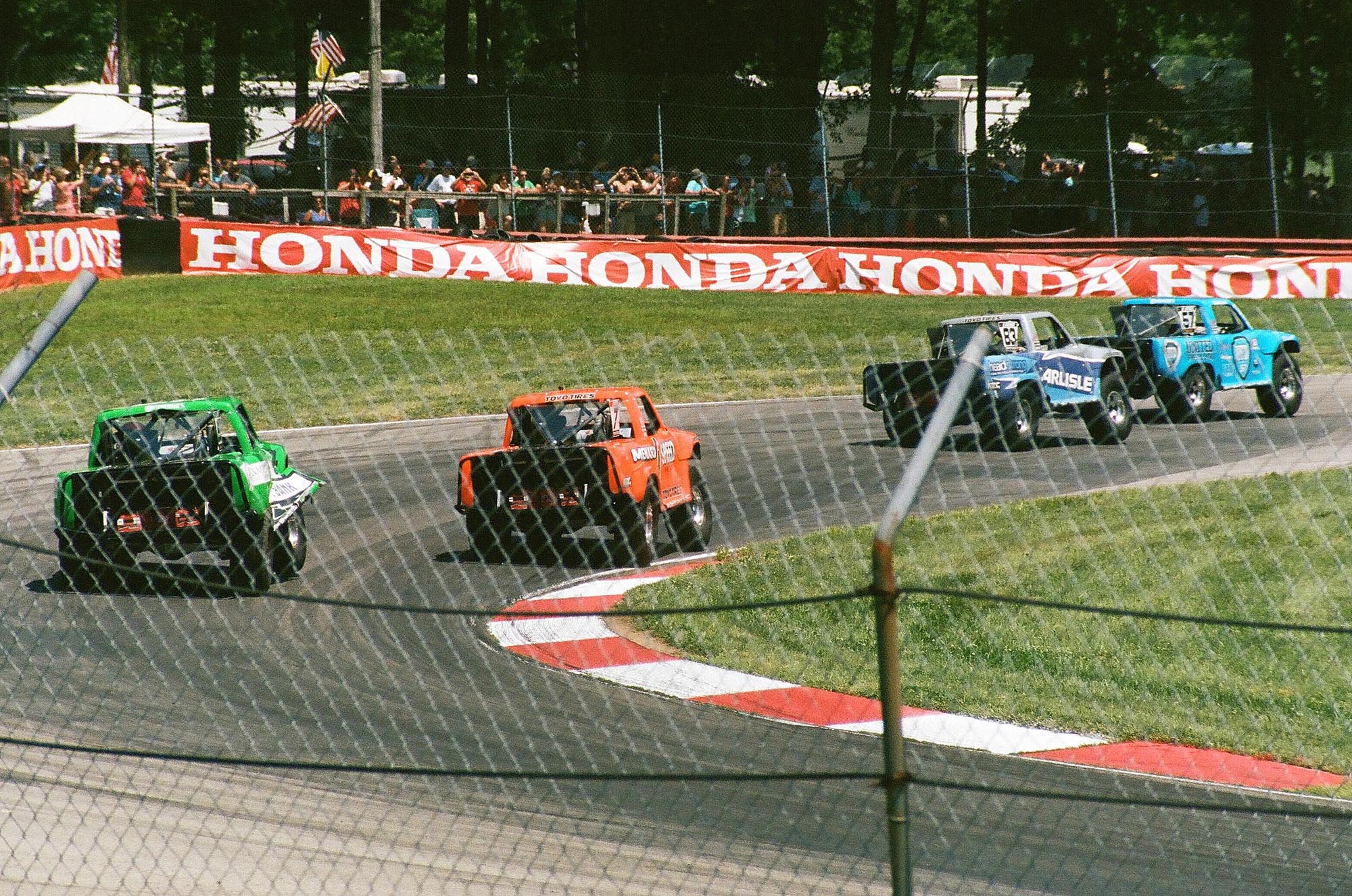 Four Stadium Super Trucks on a corner