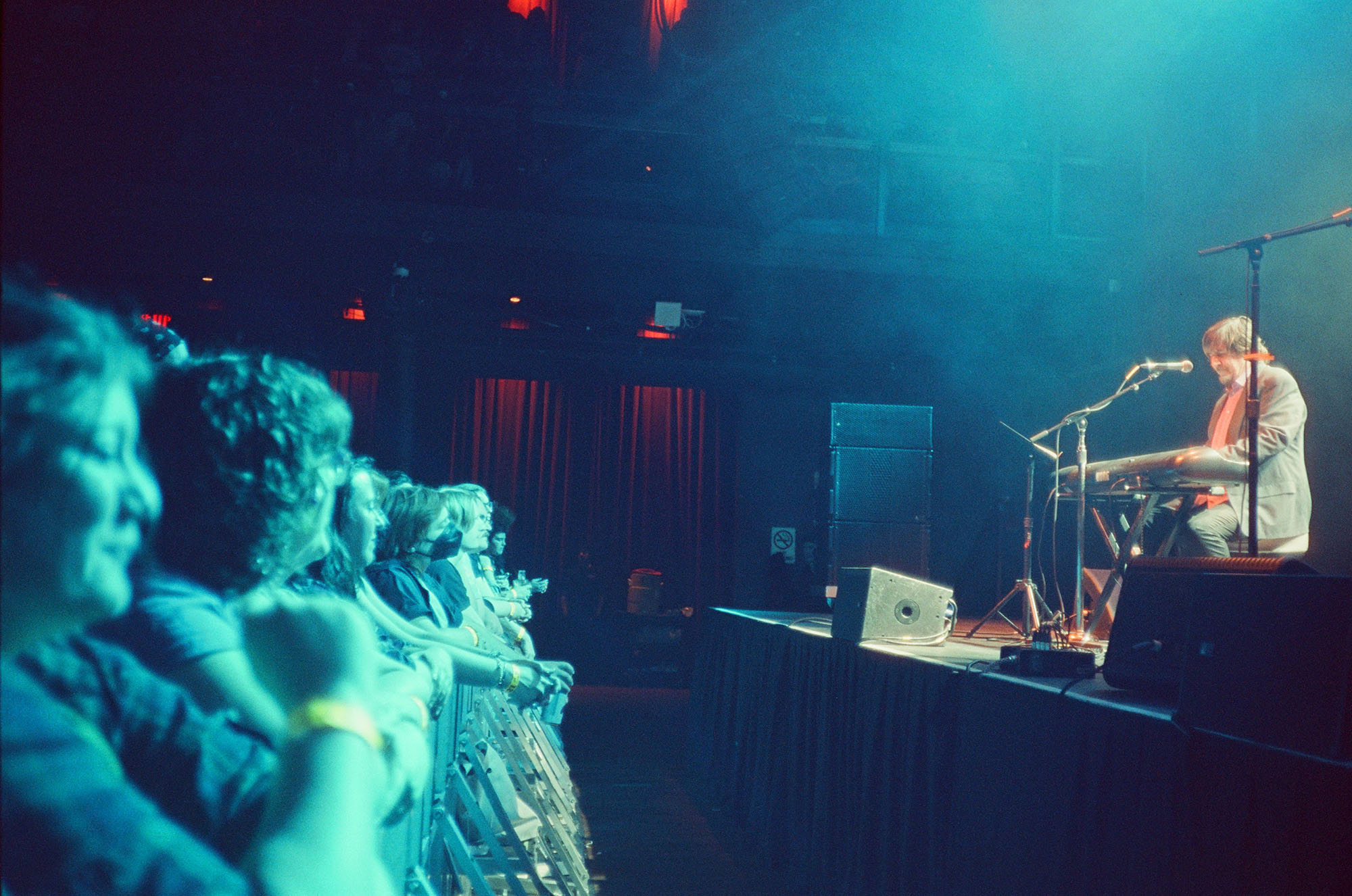 A dark picture of a singer/guitarist with their back to the crowd