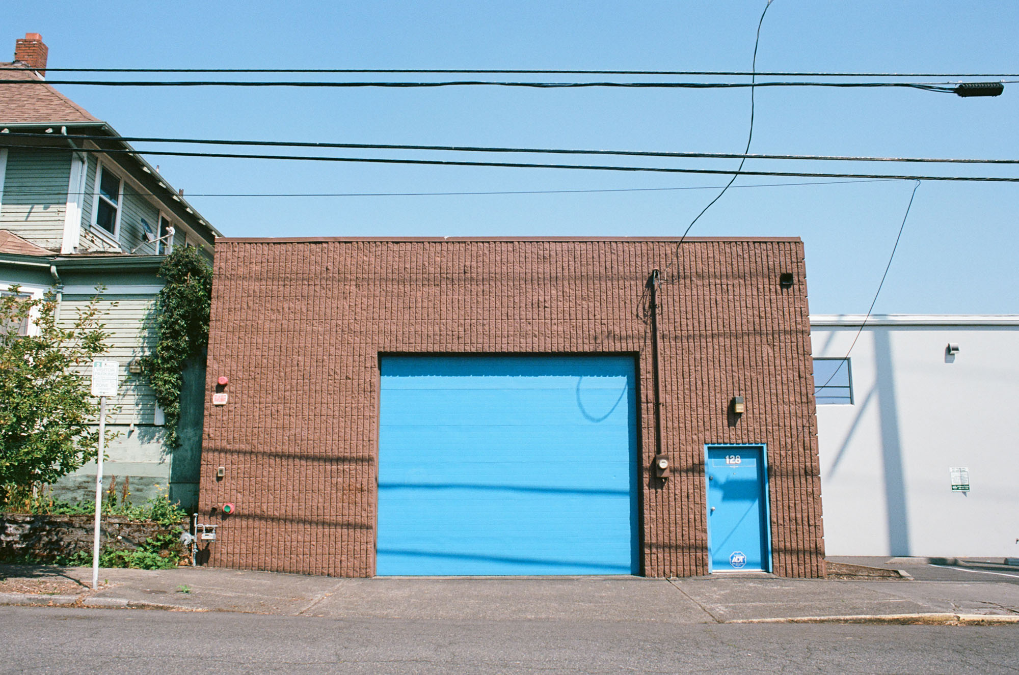 Exterior of a brick garage building with a bright blue garage door