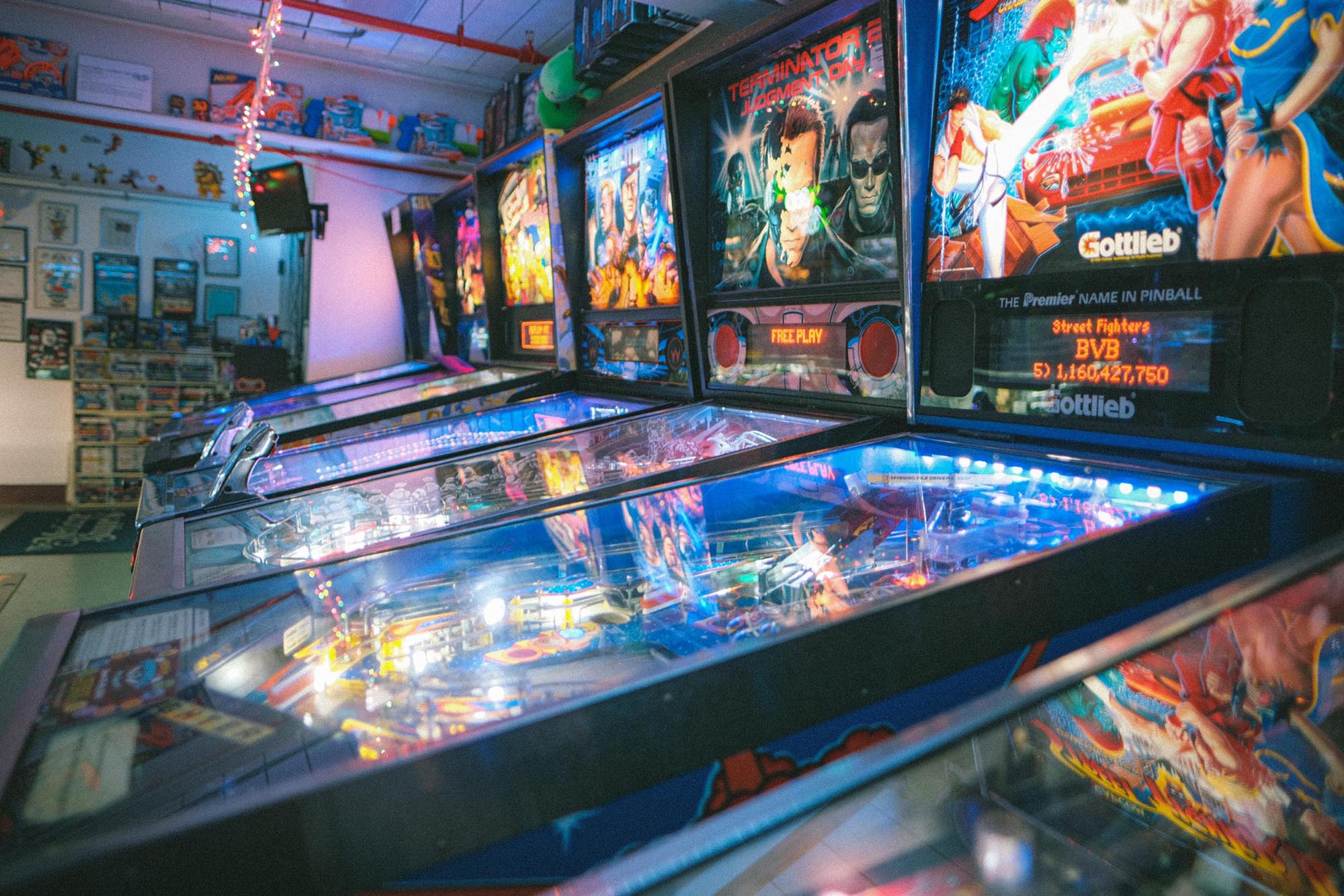 A row of pinball machines, including Terminator 2 and Street Fighter II