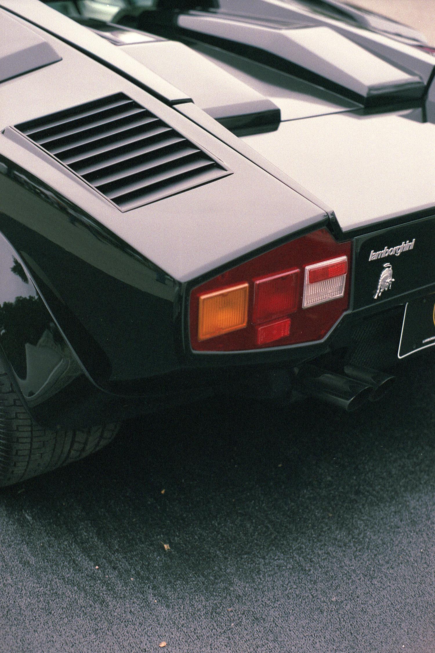 The rear corner of a black Lamborghini Countach