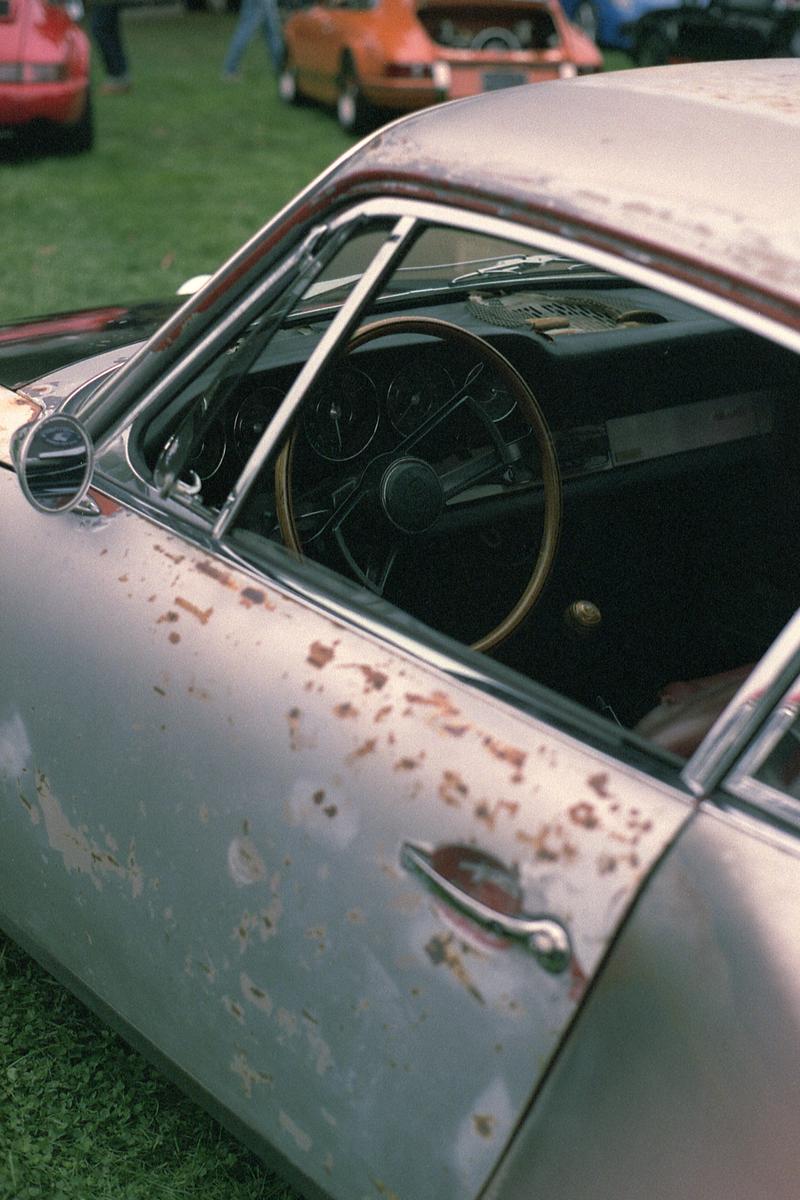 The side and interior of a rusty Porshce 356