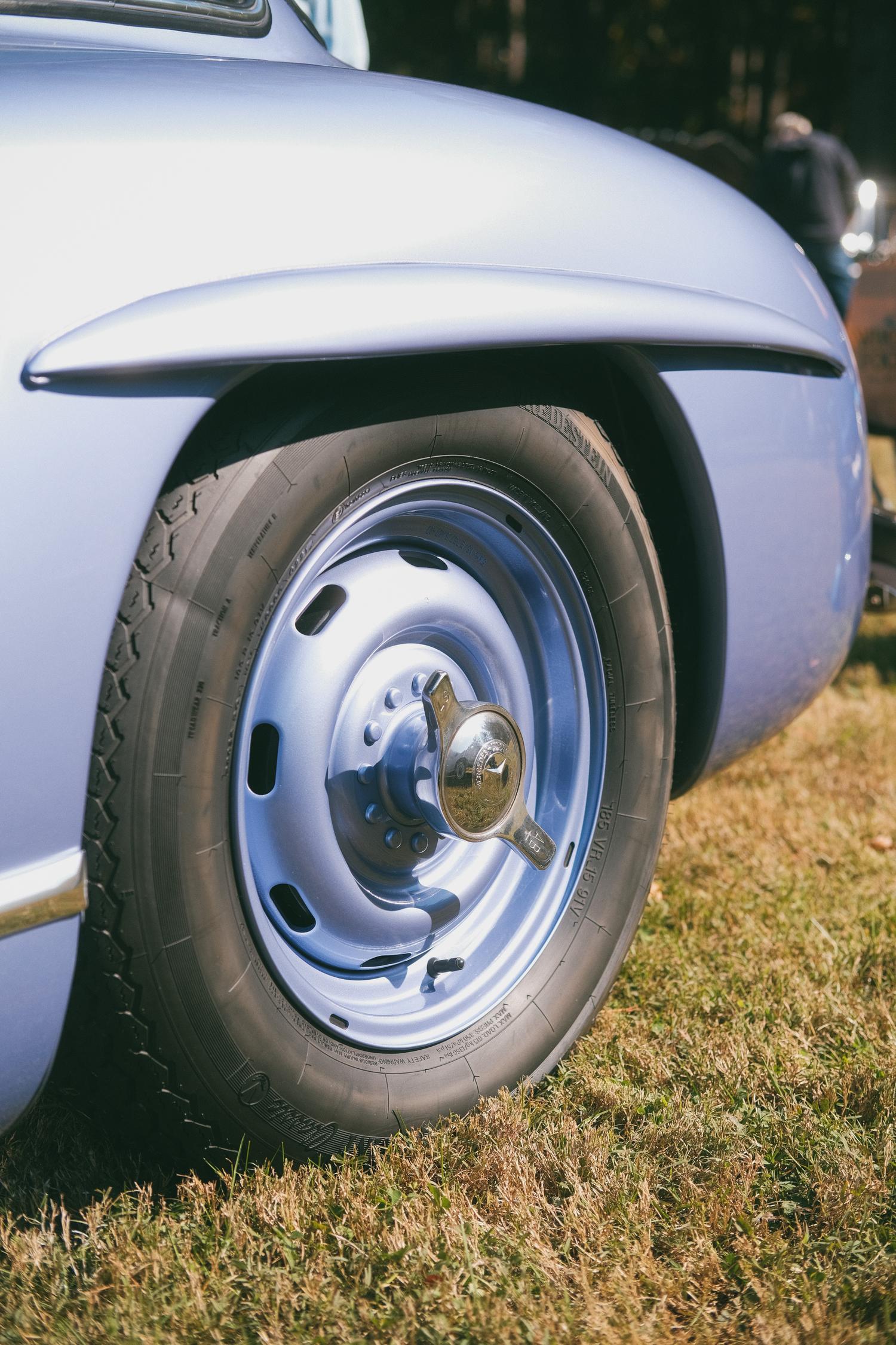 The rear wheel of a periwinkle Mercedes-Benz 300SL