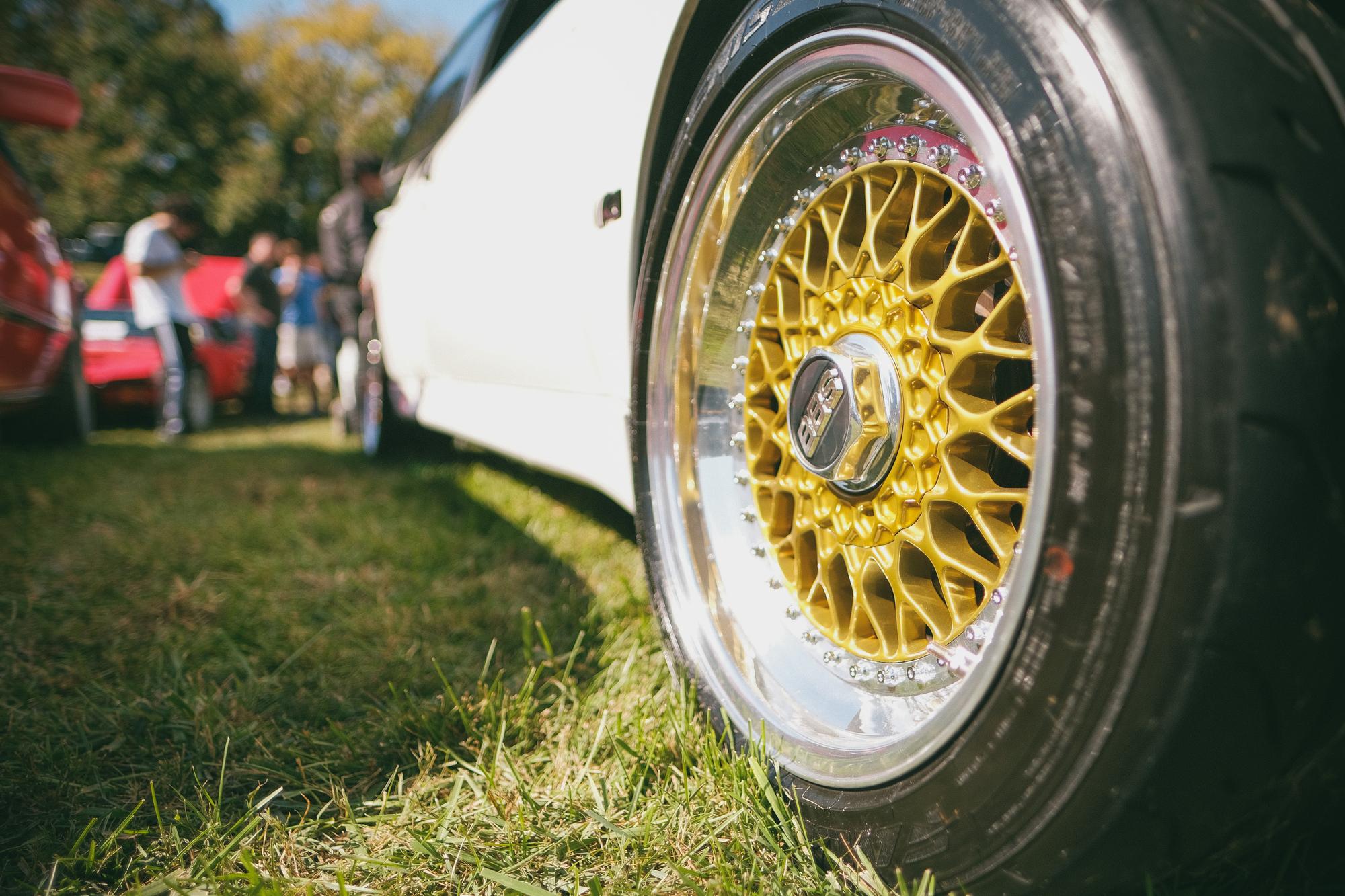 A gold front wheel of a white BMW