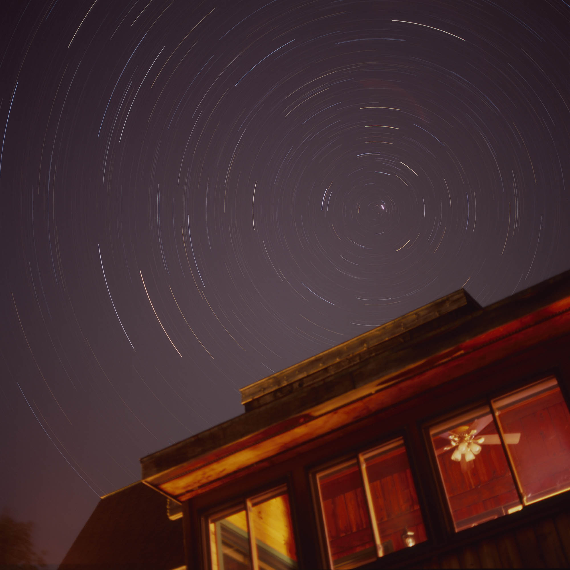 Star trails over a cabin