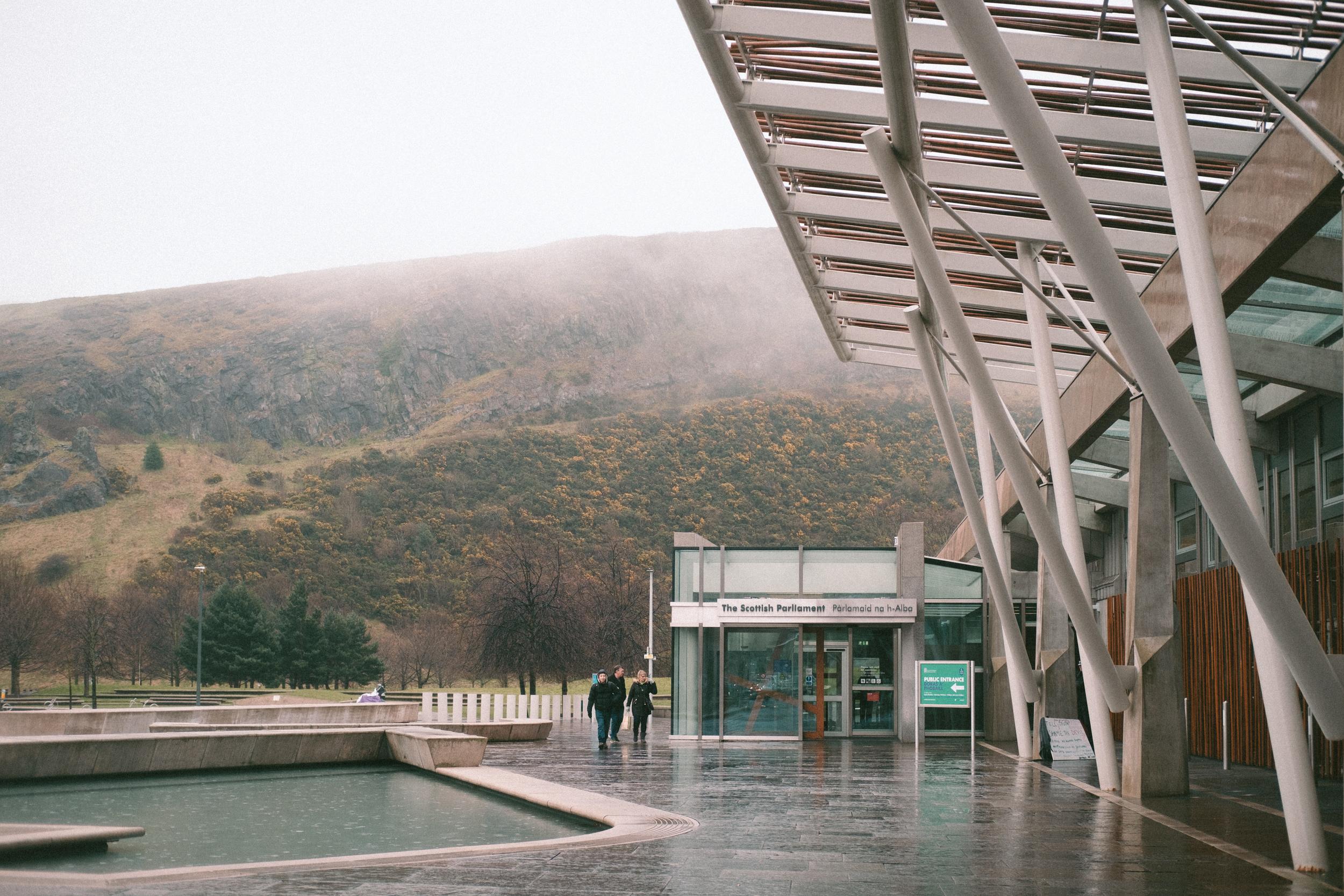 The entrance to the Scottish Parliament building in the fog and rain