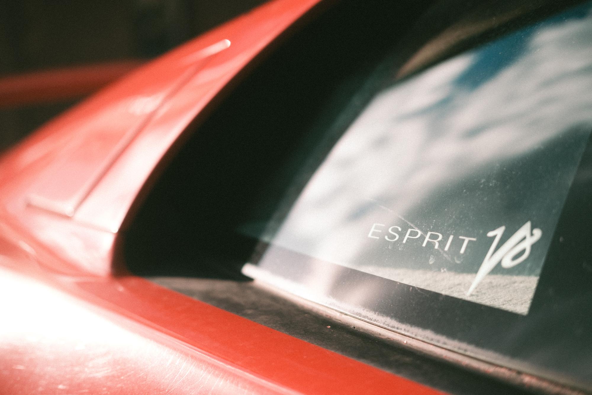 The Esprit V8 decal on the rear window of a red Lotus Esprit