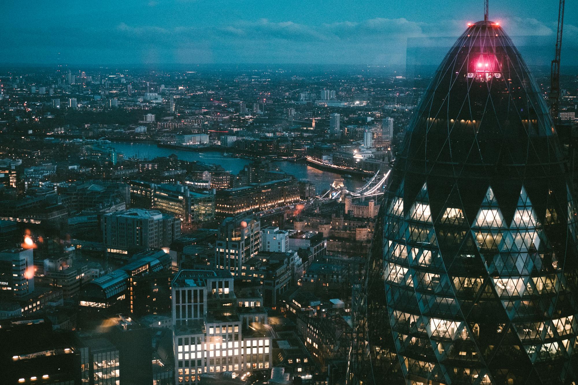 A view of London from atop a skyscraper at dusk, with the Gherkin in the foreground