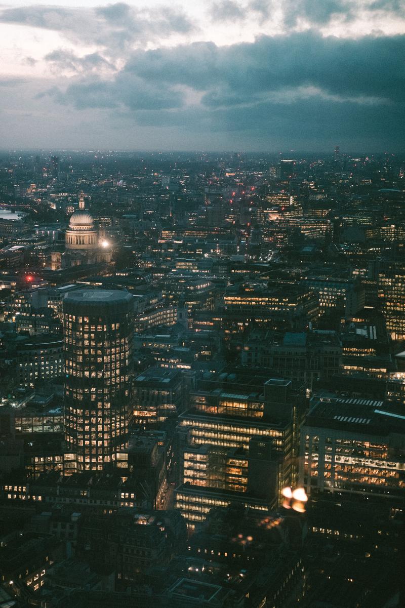 A view of London from atop a skyscraper at dusk, looking towards St. Paul's Cathedral