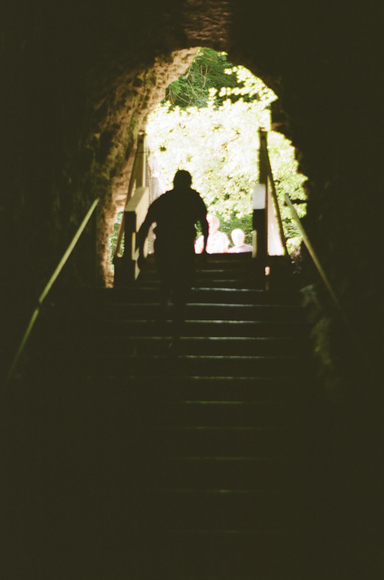 A silhouette walking up a tunnel built into the cliffside