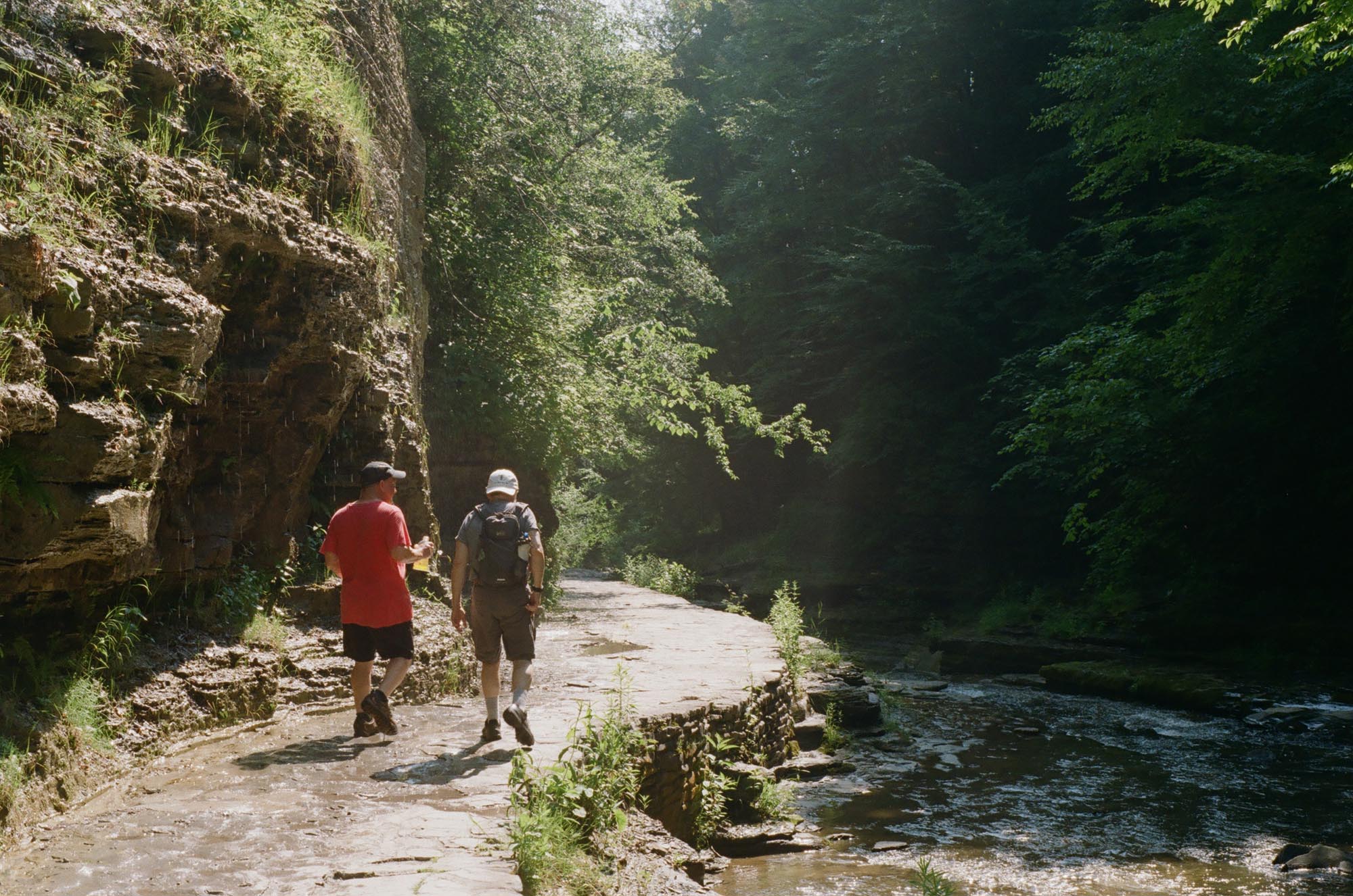 Two people walking the gorge trail next to the river