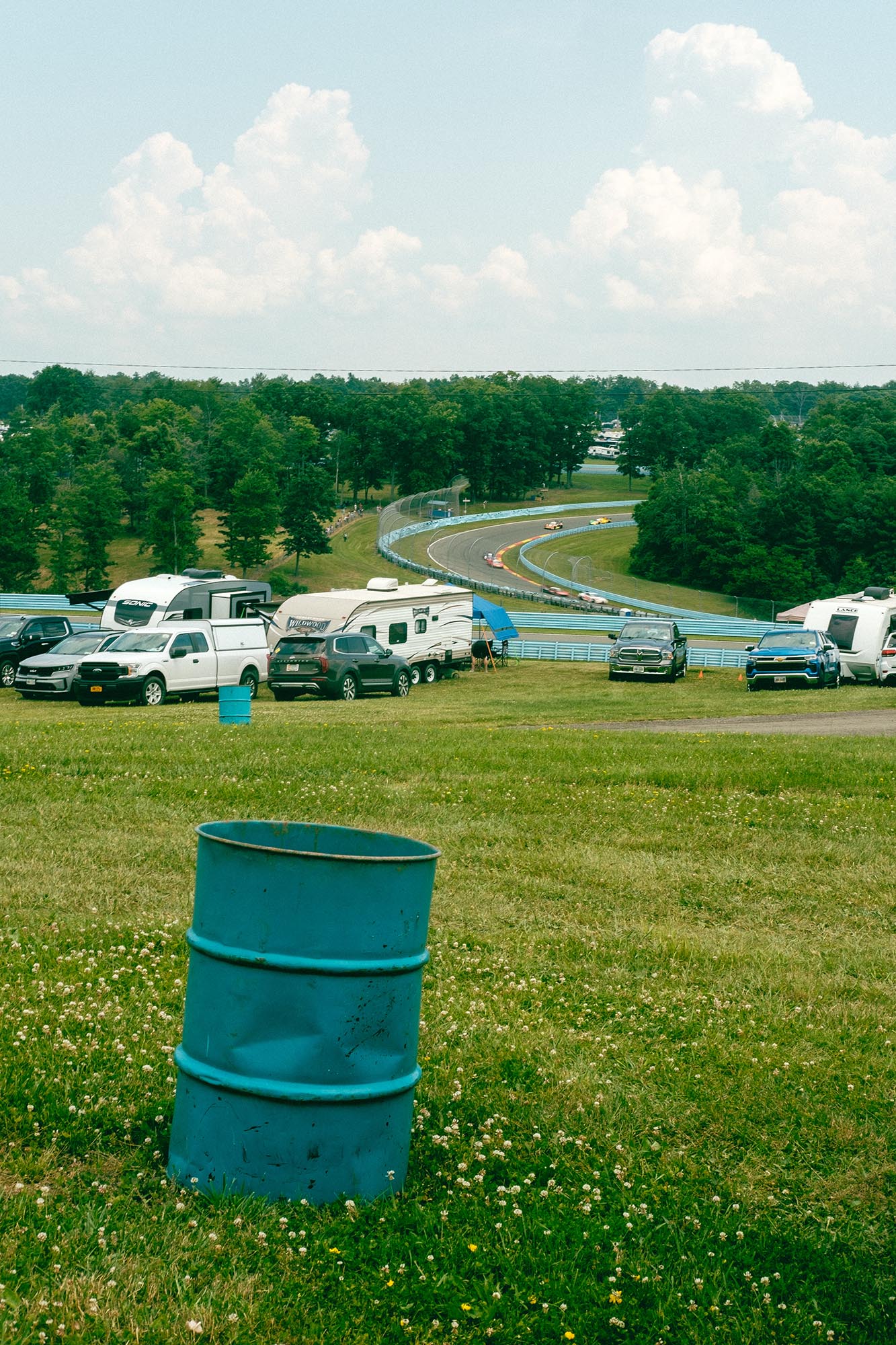 The track glimpsed from the campsite with a blue trash can in the foreground