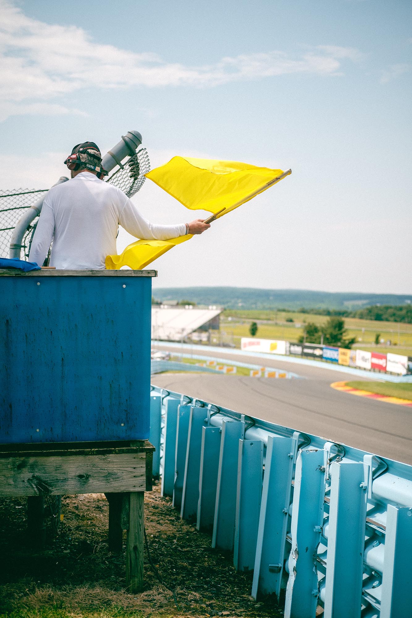 A track marshal waving double yellow flags trackside