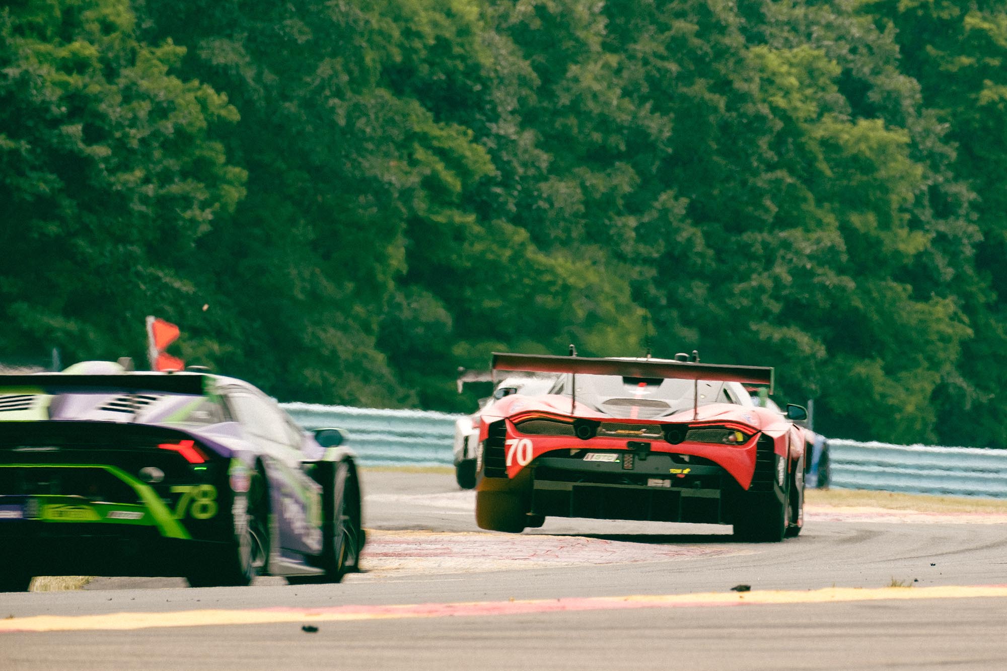 A McLaren on two wheels driving through the Bus Stop chicane