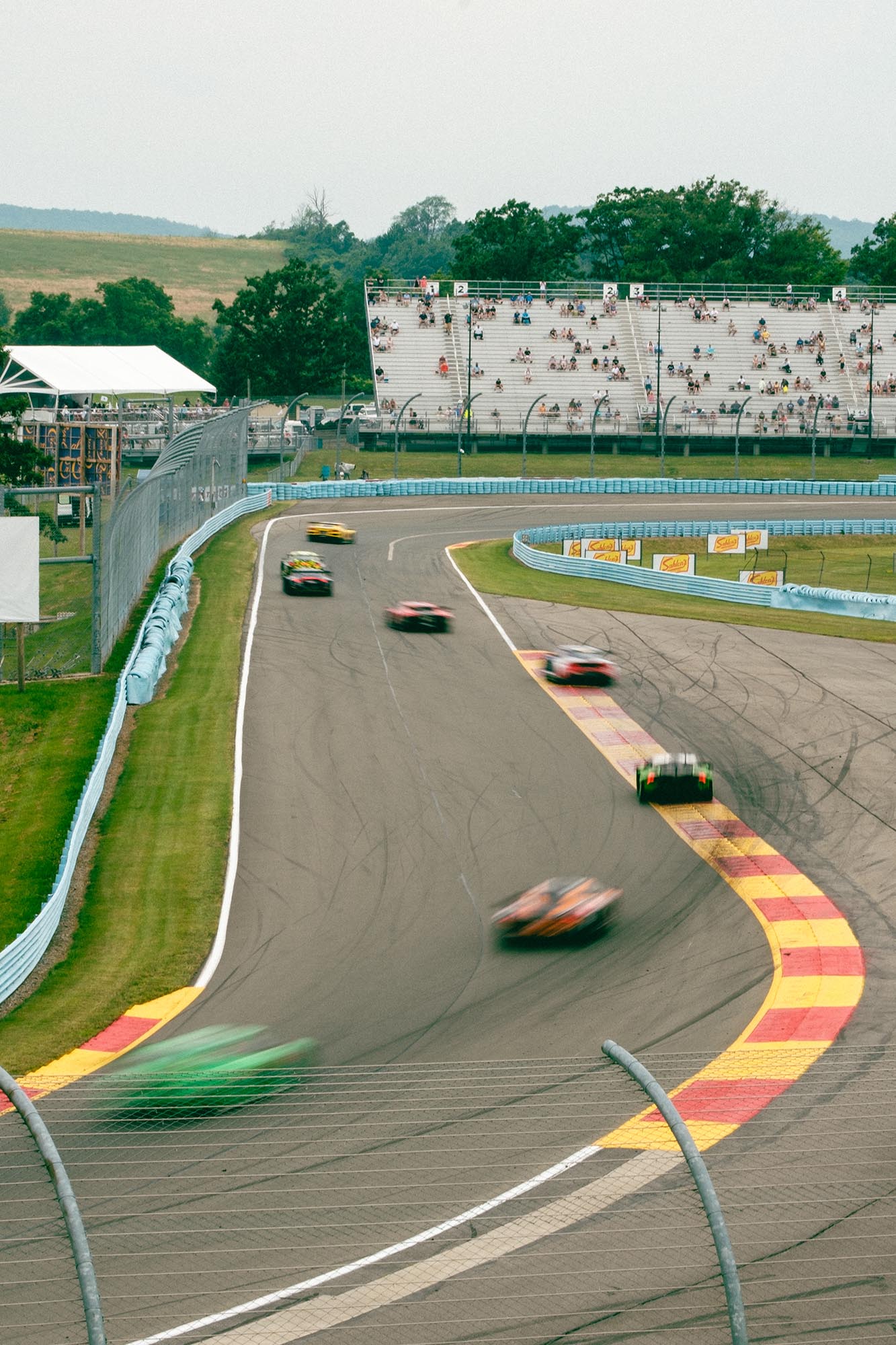 Blurred cars winding through the final two turns on track