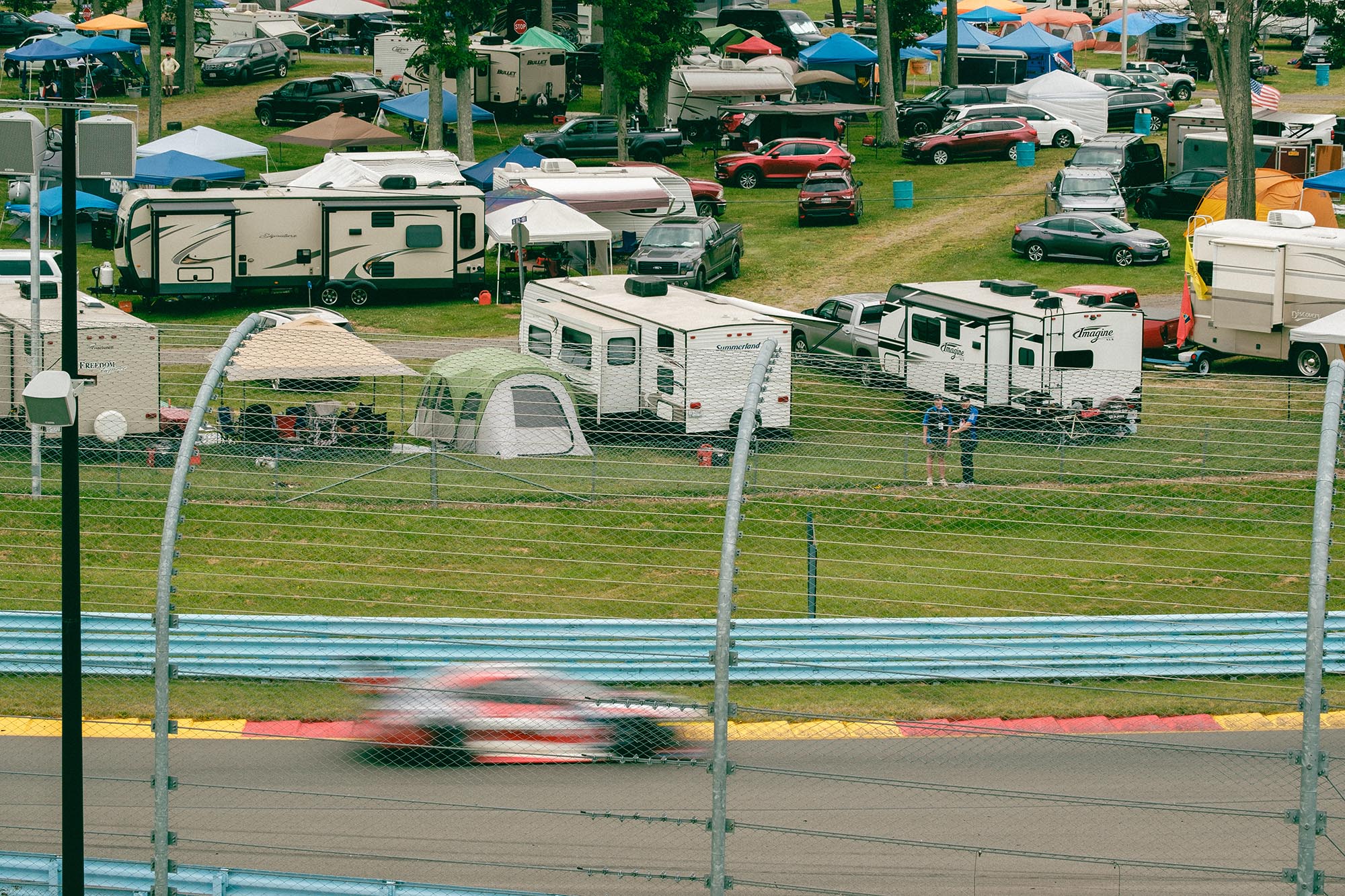 A blurred car on track in front of campgrounds