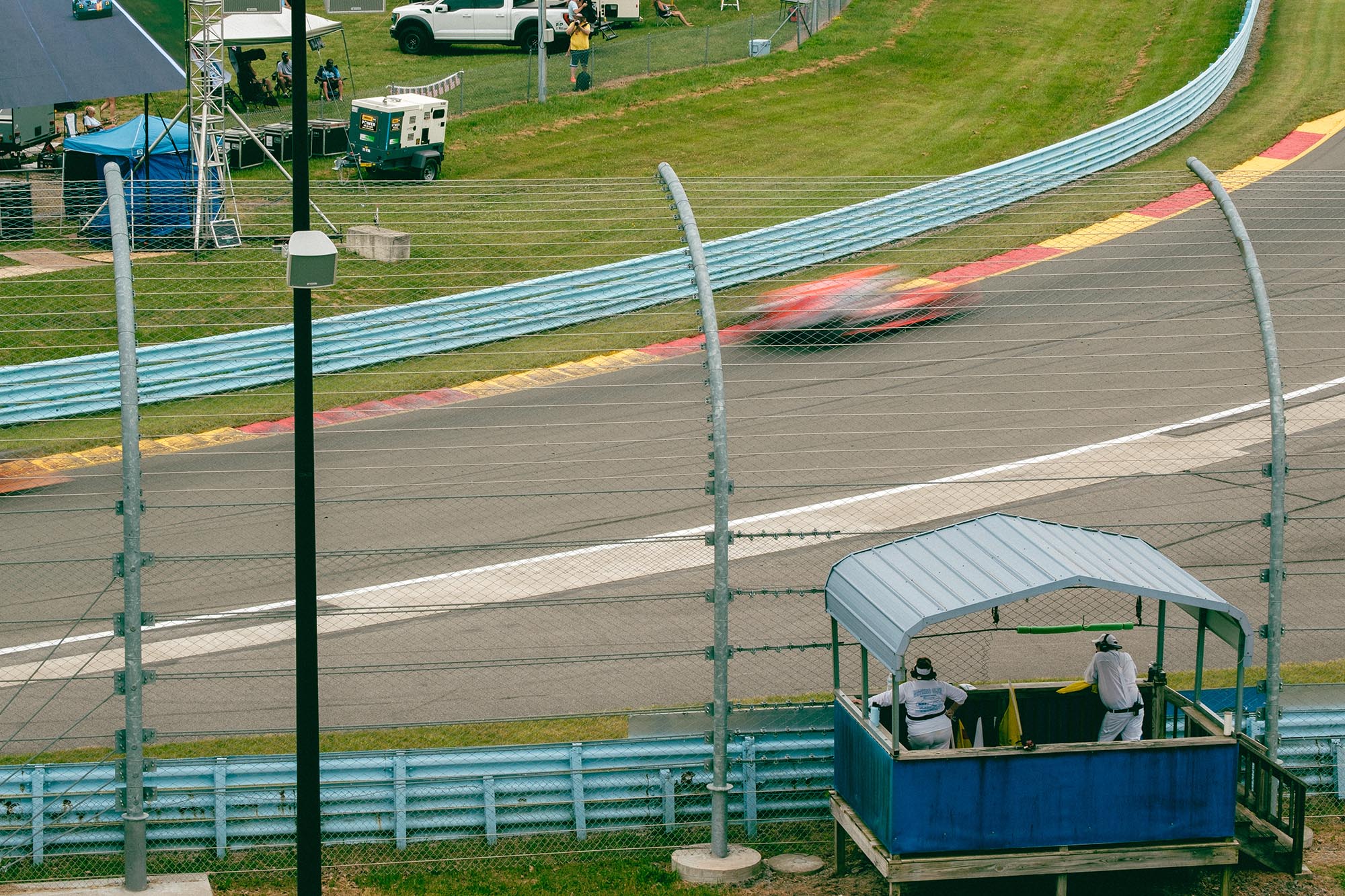 A blurred car on track in front of a marshal stand