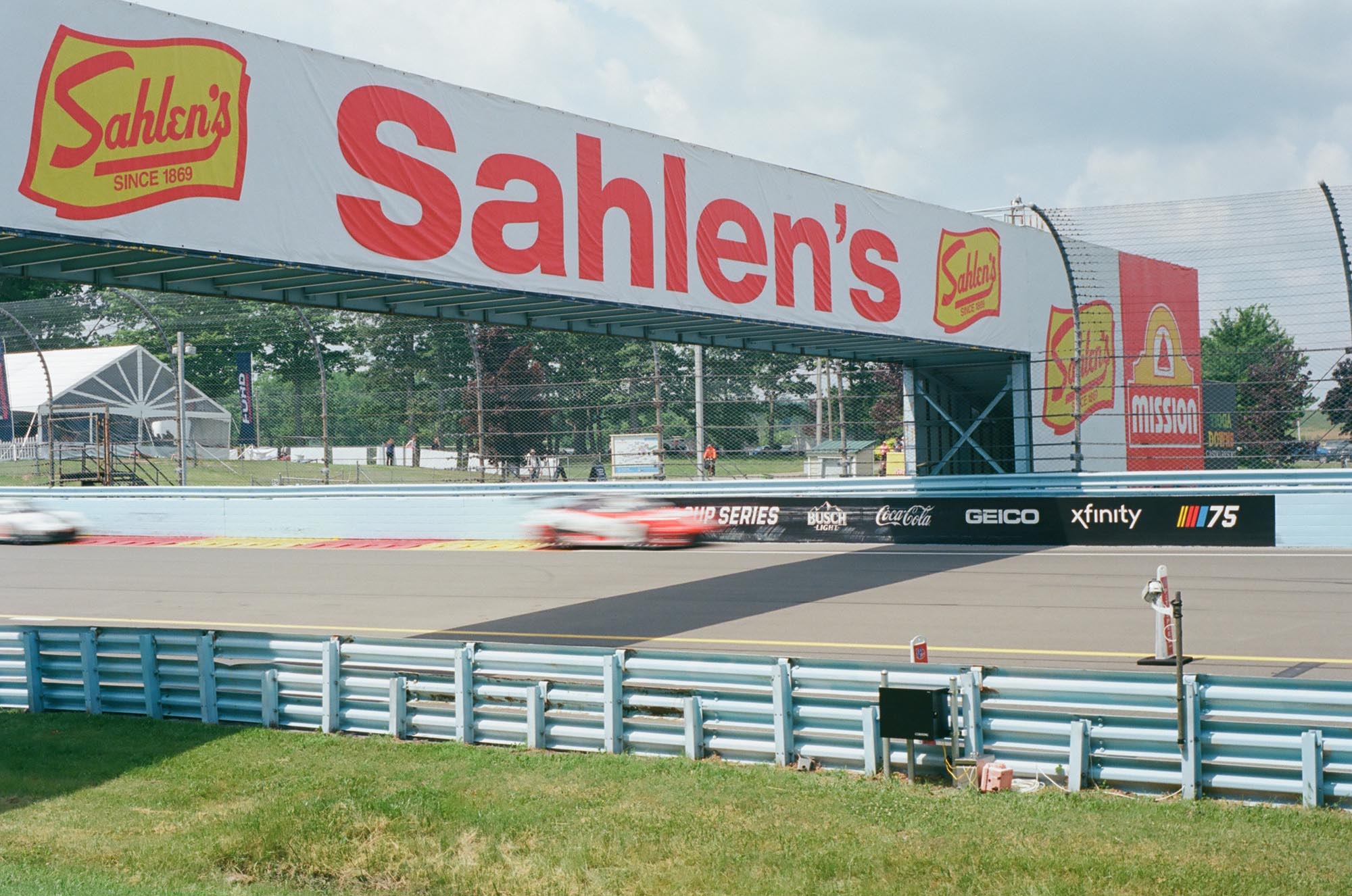 Porsche cup cars driving under the Sahlen's bridge on track