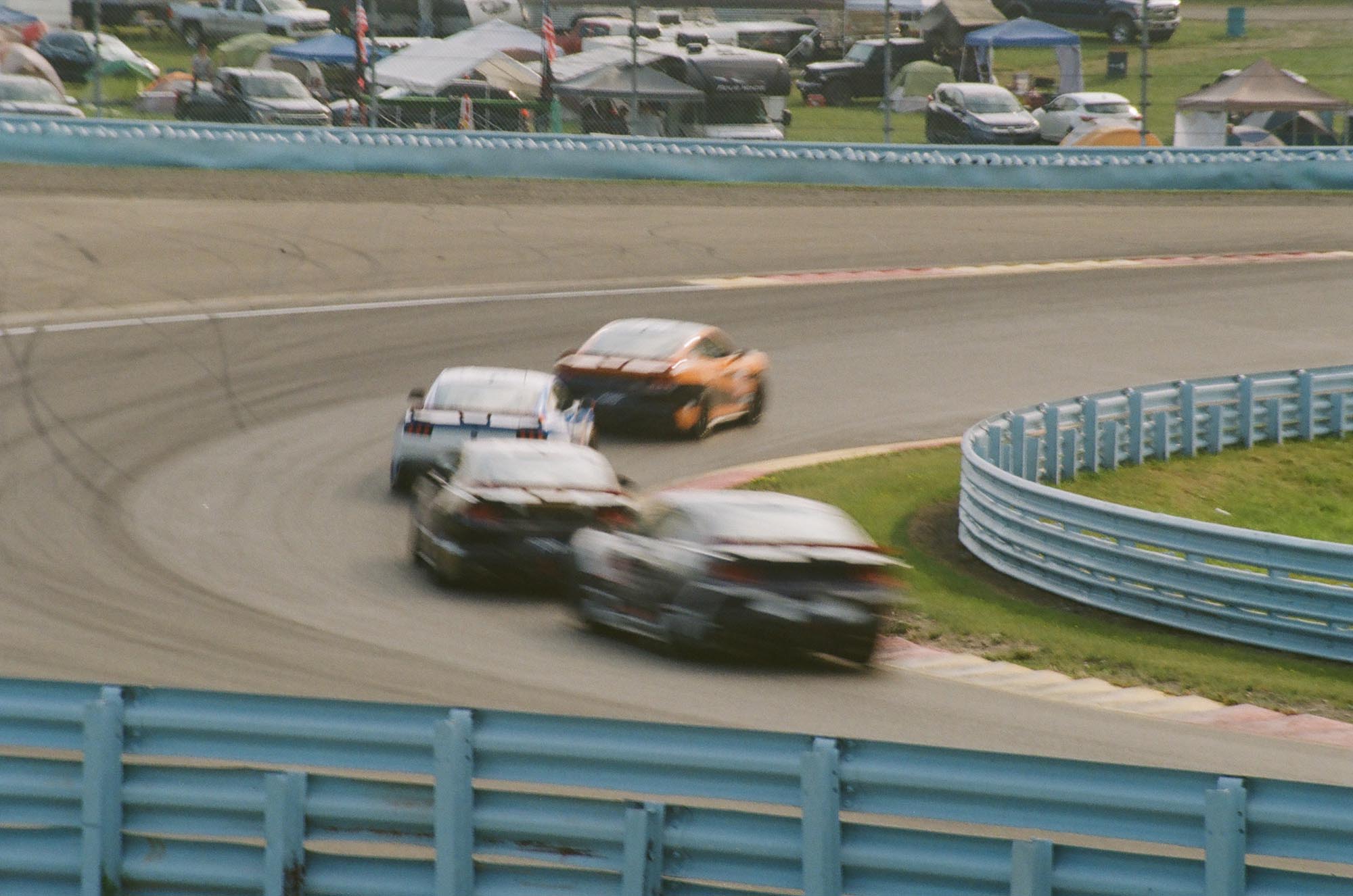 Four Ford Mustang Dark Horses driving on track