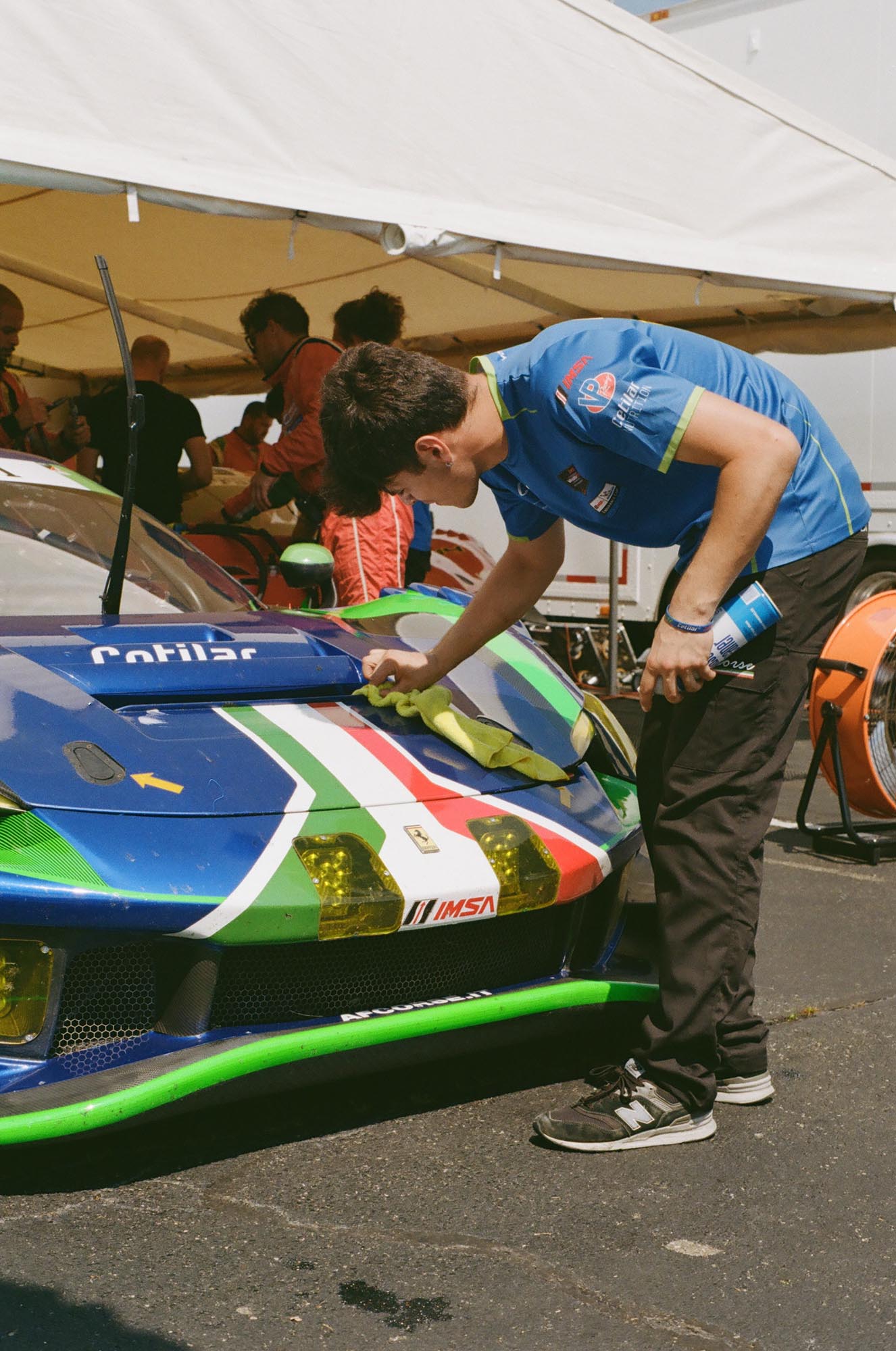 A crew member cleaning the front of a Ferrari race car